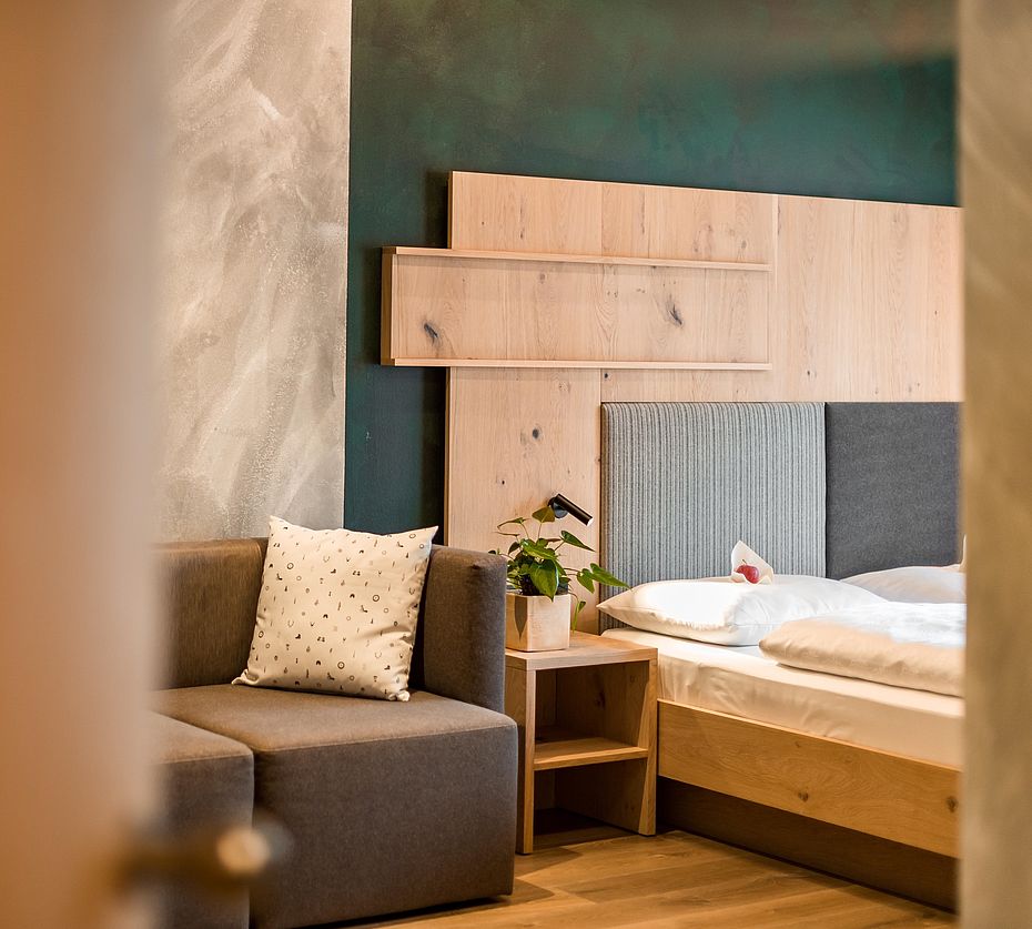 Modern hotel room with gray upholstered armchair and turquoise wall design