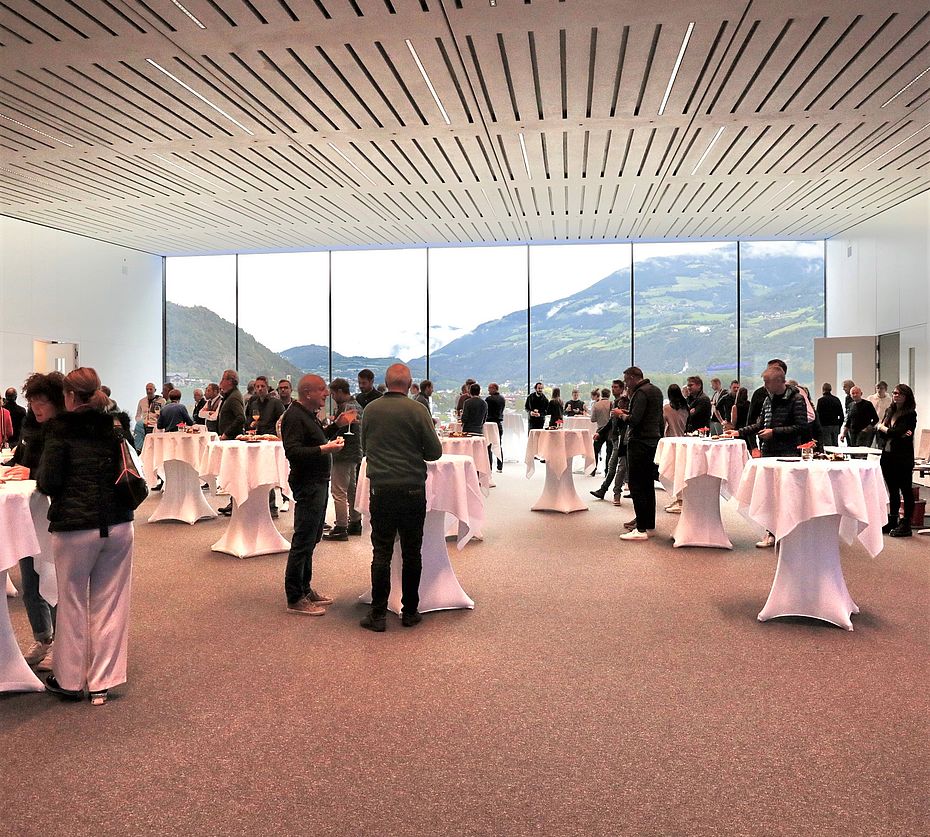 Networking event of Progress Group in modern event hall with mountain panorama